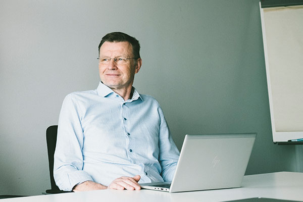 Ilkka Lähteenoja istuu työpöytänsä ääressä.